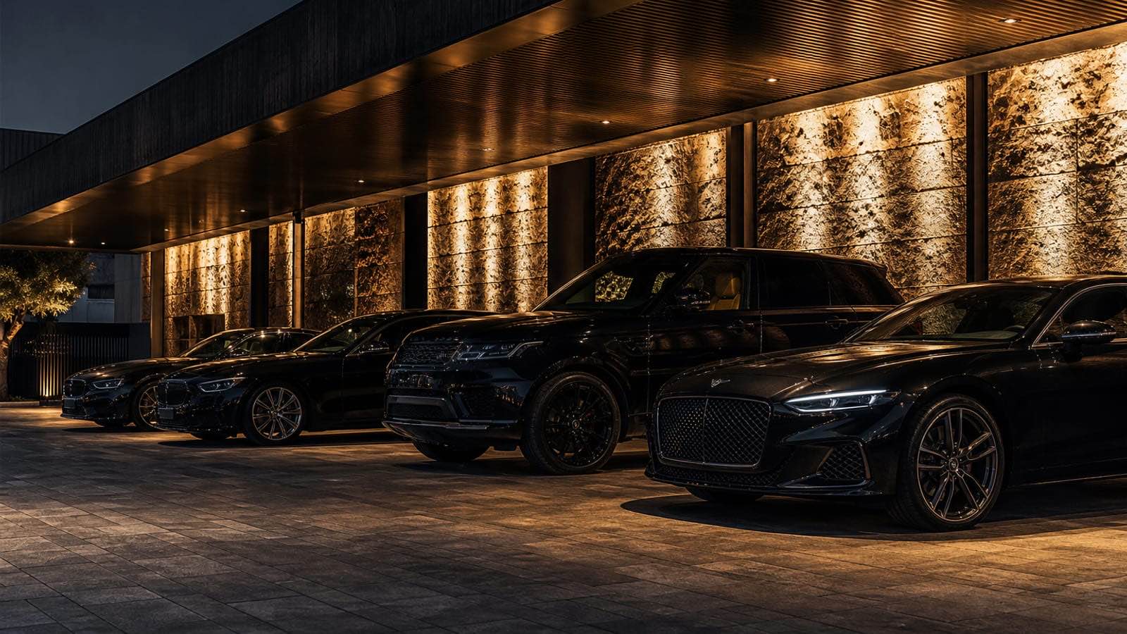 Private RoLux Club garage with luxury vehicles under warm gold uplighting